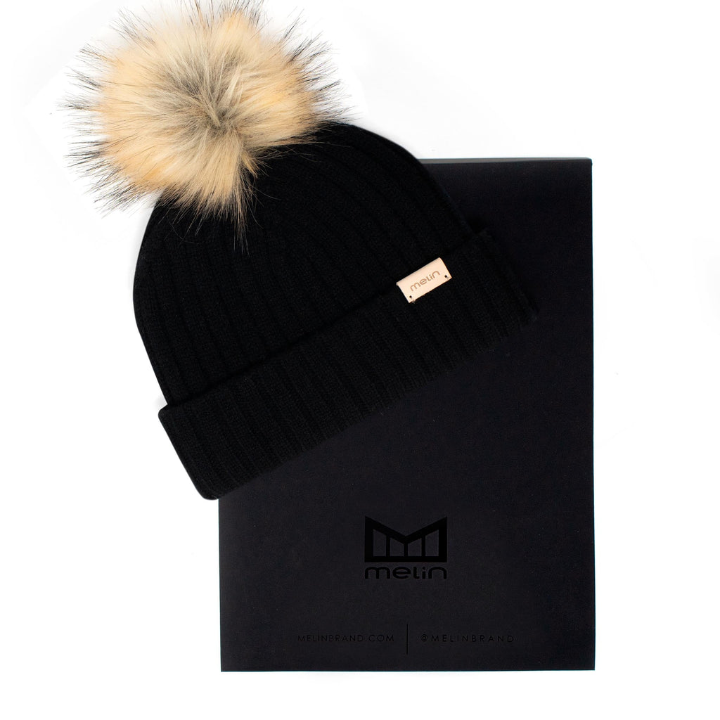 The frontal view of the Melin All-Day Pom Beanie in black next to packaging Big Image - 4